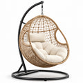 Sedia sospesa in rattan e acciaio con cuscino in poliestere color sabbia